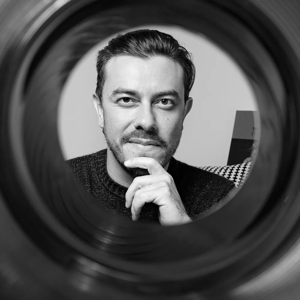 Portrait of photographer Javi Alvarez seen through a camera lens